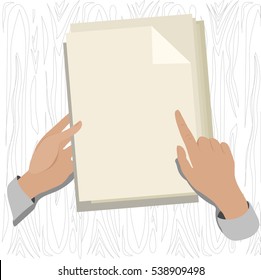 hands on the Desk holding a sheet of paper