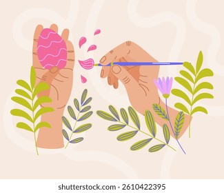 Hands painting pink Easter egg with brush surrounded by green leaves and flowers on light background. Easter celebration and springtime holidays concept. For greeting card, invitation, banner.