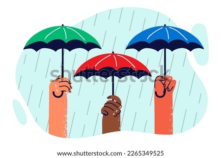 Hands of people with umbrellas protecting from heavy rain symbolizing onset of autumn with precipitation. Umbrellas and rain as metaphor for protecting multiethnic diversity over ethnic disputes