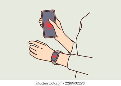 Hands of person with smartphone and fitness bracelet with picture of heart to track pulse and load on cardio system during workout. Gadgets for people involved in cardio sports and fitness