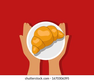 In the hands of a plate with croissant