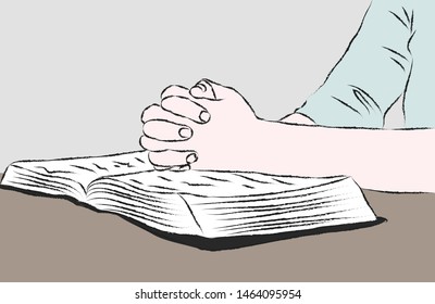 Hands praying above the Bible