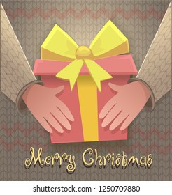 Hands with  present on the background of a sweater and merry Christmas