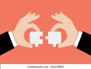 Hands pushing two jigsaw pieces together. Business teamwork concept