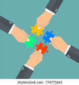 Hands Putting Puzzle Pieces Together. Teamwork Concept