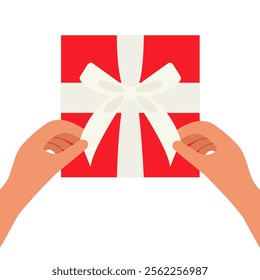 Hands untie a bow from the white ribbon on the red gift box