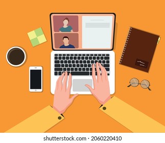 Hands using laptop, desk, coffee, notebook.
