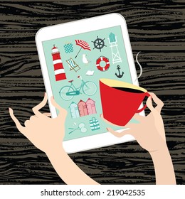 Hands woman holding a red cup of coffee and white tablet with beach icons on screen and dark wooden table