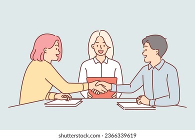 Handshake of business partners sitting at negotiating table, discussing terms of deal. Handshake of man and woman after conclusion of marriage contract that allows you to stay safe after wedding