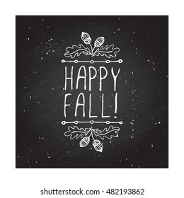 Hand-sketched typographic element with acorns and text on blackboard background. Happy Fall