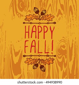 Hand-sketched typographic element with acorns and text on wooden background. Happy Fall