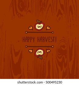 Hand-sketched typographic element with apple, hearts and text on wooden background. Happy harvest