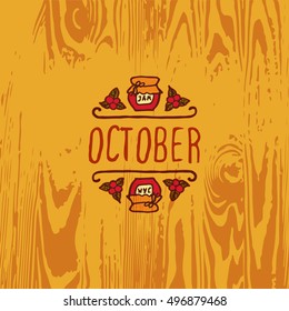 Hand-sketched typographic element with jam, berries and text on wooden background. October