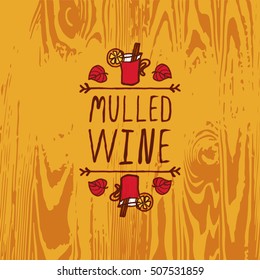 Hand-sketched typographic element with mulled wine, leaves and text on wooden background. Mulled wine