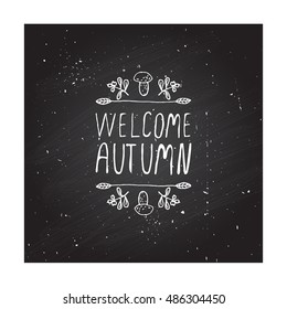 Hand-sketched typographic element with mushroom, berries and text on chalkboard background. Welcome autumn