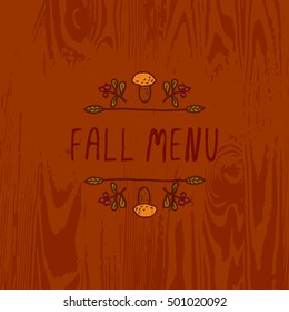 Hand-sketched typographic element with mushroom, berries and text on wooden background. Fall menu
