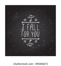 Hand-sketched typographic element with umbrella, hearts and text on chalkboard background. I fall for you