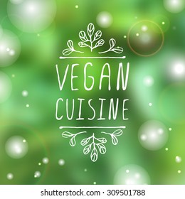 Hand-sketched typographic element.   Vegan cuisine  - product label on blurred background. Suitable for ads, signboards, packaging and identity and web designs.