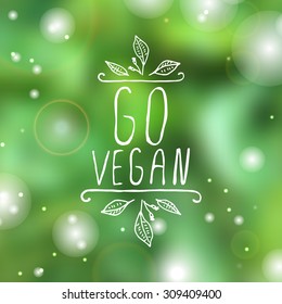 Hand-sketched typographic element. Vegan product label on blurred background. Suitable for ads, signboards, packaging and identity and web designs.