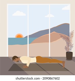 A handsome fit African American man standing in a low plank or chaturanga dandasana pose, doing yoga at home with a dog while sunrise (early morning).