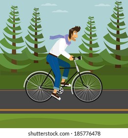 Handsome guy is riding a bicycle in the park