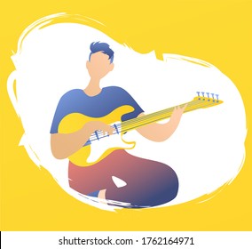 A handsome young guy a guitarist playing an electric guitar. The musician performs rock and roll in a white spot on a yellow background. The musician is sitting with a guitar. 