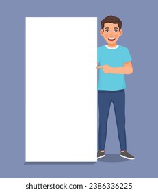 Handsome young man standing beside blank banner pointing finger copyspace for ads