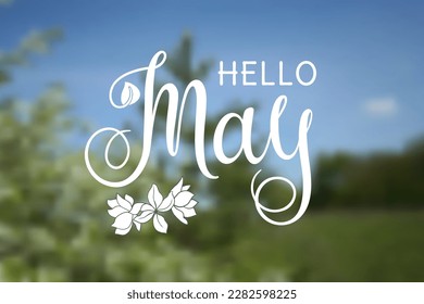 Handwritten, hello may, lettering message. May welcome quote with leaves . Modern lettering. May design for cards, banners, posters. Blurred background.