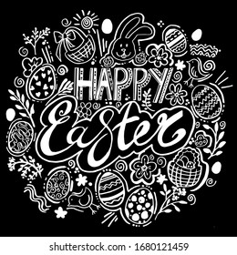 Handwritten inscription of happy Easter with decorative elements around.white letters on a black background in  frame of flowers, twigs,eggs,and ornaments.Lettering on a chalkboard.