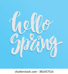 Handwritten lettering "Hello spring". Brush Pen modern calligraphy isolated on blue background 