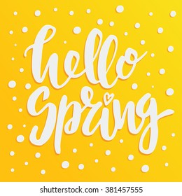 Handwritten lettering "Hello spring". Brush Pen modern calligraphy isolated on yellow background with white dots. 