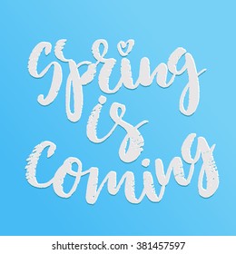 Handwritten lettering "Spring is coming". Brush Pen modern calligraphy isolated on blue background 