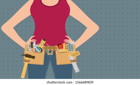 Handywoman with hands on waist and tool belt on grey peg board background, repair and DIY concept
