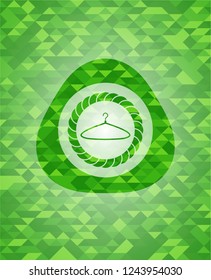 hanger icon inside green emblem with triangle mosaic background