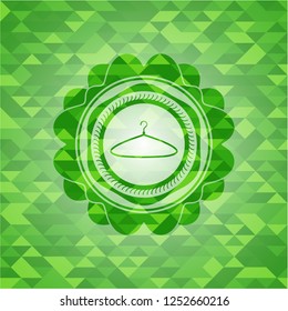 hanger icon inside green emblem with triangle mosaic background