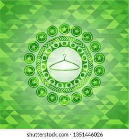 hanger icon inside green emblem with mosaic ecological style background