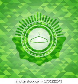 hanger icon inside green emblem. Mosaic background. 