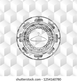 hanger icon inside grey emblem with geometric cube white background