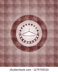 hanger icon inside red seamless emblem with geometric background.