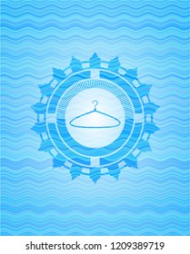 hanger icon inside sky blue water wave emblem.