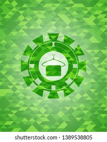 hanger with towel icon inside green emblem with triangle mosaic background
