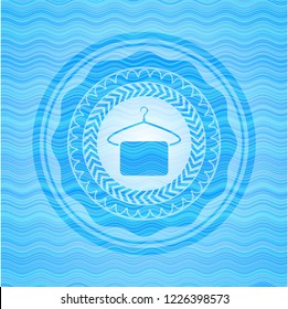 hanger with towel icon inside light blue water emblem background.