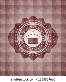 hanger with towel icon inside red seamless badge with geometric background.