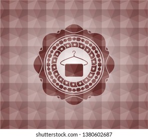 hanger with towel icon inside red seamless badge with geometric background.