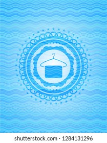 hanger with towel icon inside sky blue water wave emblem.
