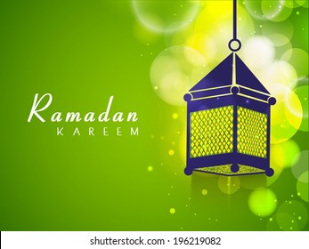 Hanging arabic lantern on shiny green background for celebration for holy month of Muslim community Ramadan Kareem.