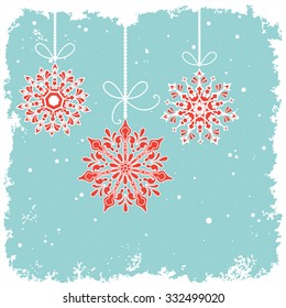 Hanging bauble snowflakes over grunge snowy background - room for your input 