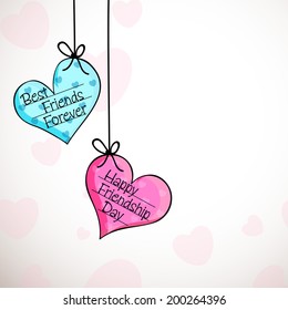 Hanging colorful hearts with stylish text Happy Friendship Day on grey background. 