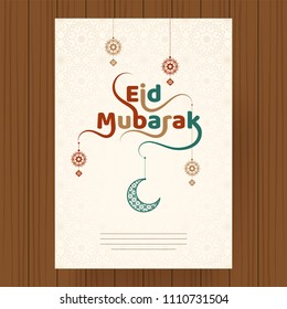 Hanging crescent moon and floral elements decorated stylish text Eid Mubarak. Greeting card design on wooden background.