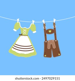 hängendes Dirndl und Lederhosen grünbrauner blauer Hintergrund